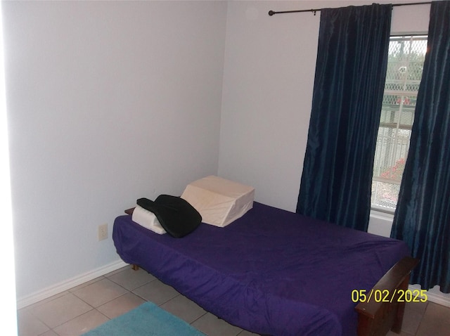 tiled bedroom with baseboards and multiple windows