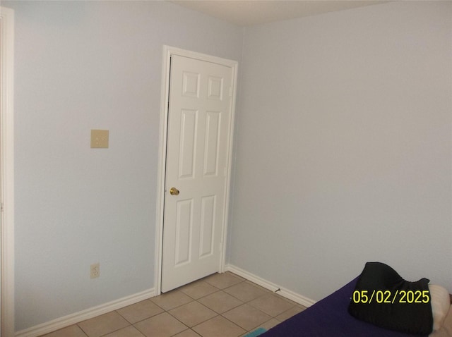 interior space featuring light tile patterned floors and baseboards
