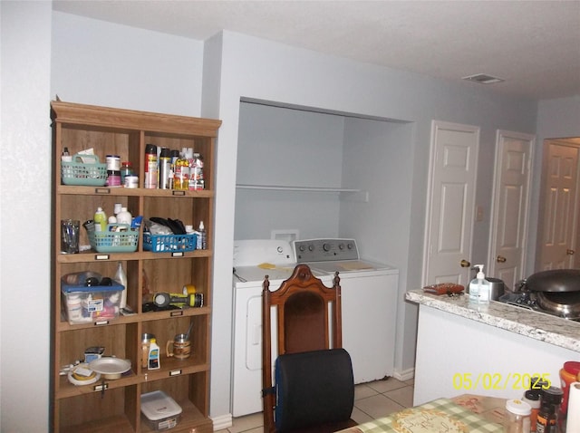 laundry room featuring washer and clothes dryer, laundry area, light tile patterned floors, and visible vents