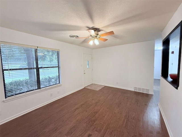 152 N Imperial Dr, Denison, TX 75020 - spare room with dark wood-style flooring, ceiling fan, and a textured ceiling