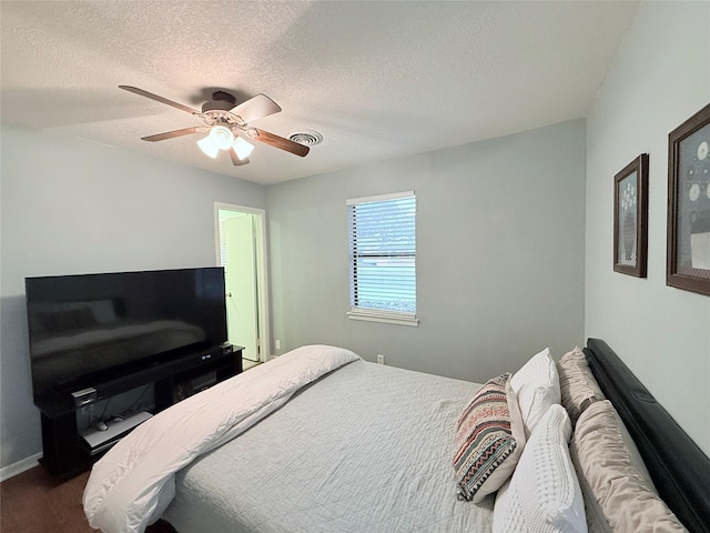 152 N Imperial Dr, Denison, TX 75020 - bedroom with a textured ceiling, a ceiling fan, and dark colored carpet