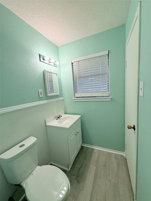 152 N Imperial Dr, Denison, TX 75020 - half bath featuring wood finished floors, vanity, a textured ceiling, and wainscoting