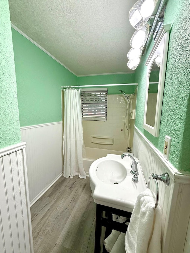 152 N Imperial Dr, Denison, TX 75020 - bathroom featuring a textured ceiling, shower / bathtub combination with curtain, wood finished floors, a wainscoted wall, and vanity