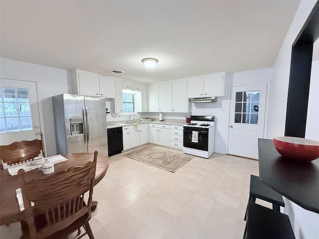 152 N Imperial Dr, Denison, TX 75020 - kitchen with white gas range oven, stainless steel fridge, black dishwasher, under cabinet range hood, and light countertops