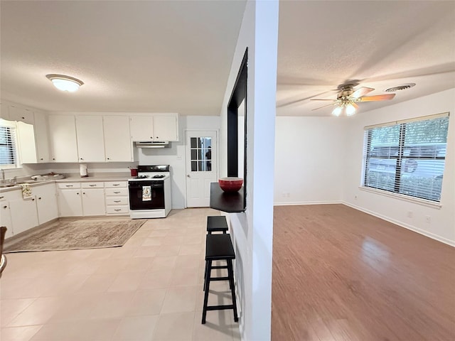 152 N Imperial Dr, Denison, TX 75020 - kitchen featuring white range with gas cooktop, under cabinet range hood, a ceiling fan, white cabinetry, and a textured ceiling