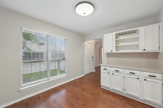 interior space with dark wood-type flooring and baseboards