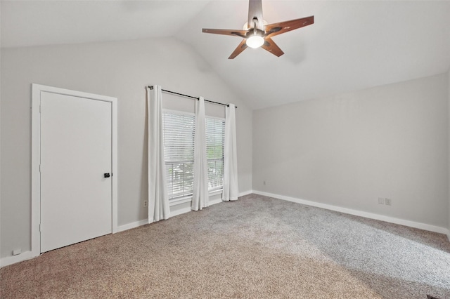 interior space with a ceiling fan, baseboards, carpet floors, and vaulted ceiling