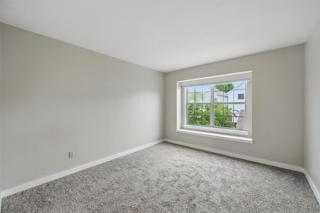 carpeted spare room with baseboards