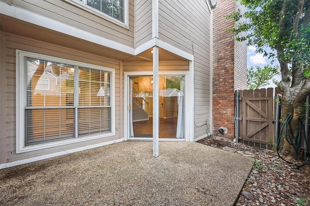 entrance to property featuring a gate and a patio