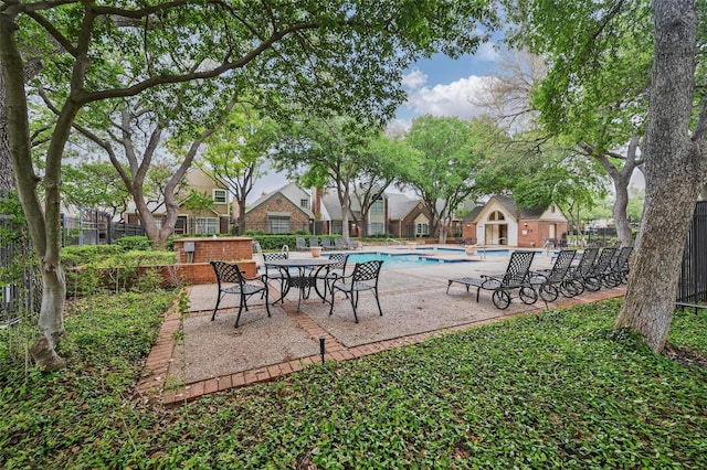 view of patio with fence and a community pool