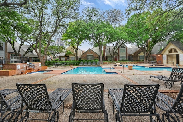 pool with a patio and fence