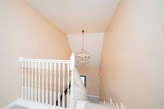 staircase with vaulted ceiling, a chandelier, and baseboards