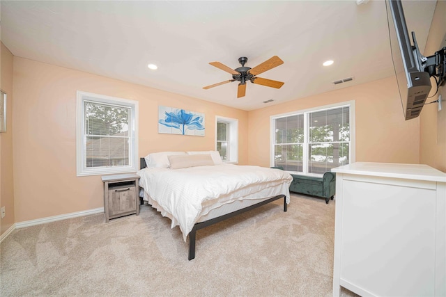 bedroom featuring light colored carpet, baseboards, visible vents, and multiple windows