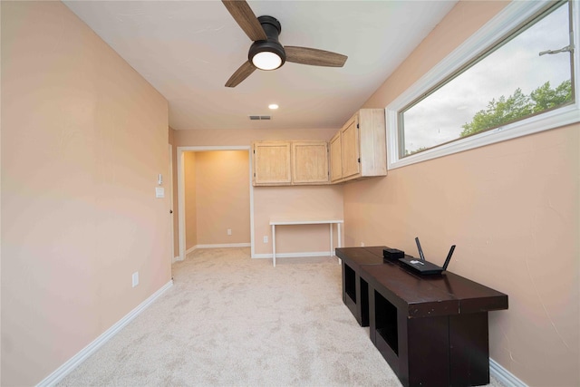 hall with visible vents, baseboards, and light carpet