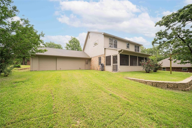 rear view of property with a lawn, brick siding, a sunroom, and an attached garage
