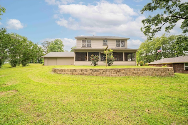 back of property with a sunroom, a yard, and a garage