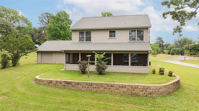 view of front facade featuring a front yard, roof with shingles, and a sunroom