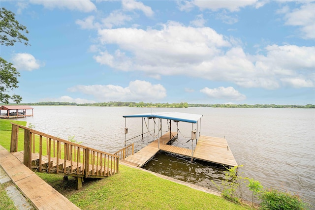 dock area featuring a yard, boat lift, and a water view