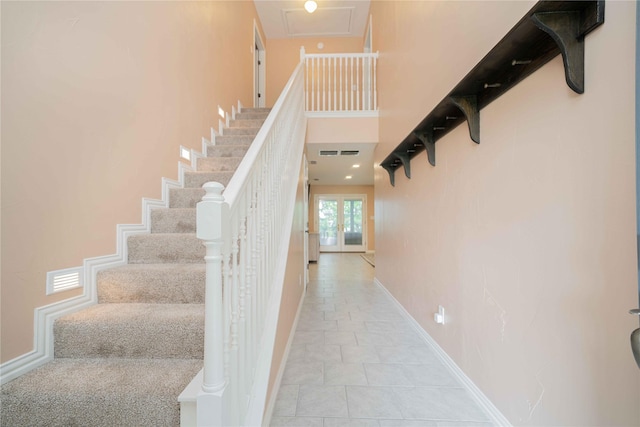 stairway featuring baseboards, visible vents, and tile patterned floors
