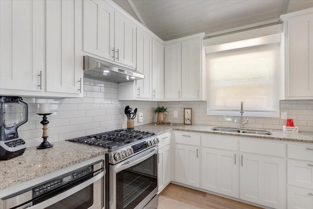 10 Holland St, Pottsboro, TX 75076 - kitchen with under cabinet range hood, stainless steel gas stove, a sink, and white cabinets