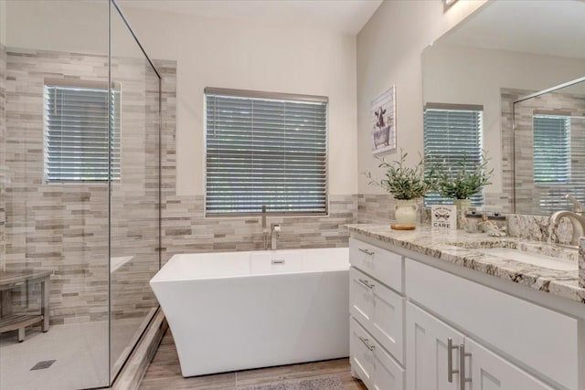 10 Holland St, Pottsboro, TX 75076 - full bath featuring a shower stall, tile walls, a freestanding bath, and vanity