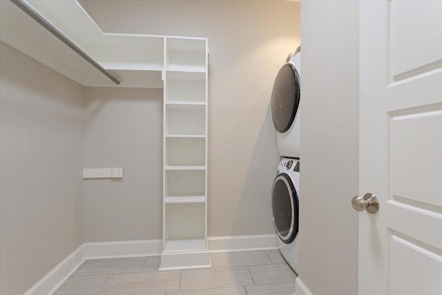 10 Holland St, Pottsboro, TX 75076 - laundry area featuring stacked washer and clothes dryer, light tile patterned floors, and baseboards