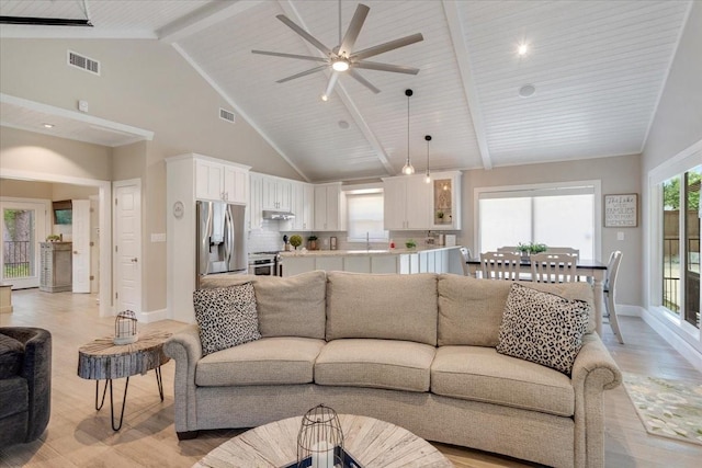 10 Holland St, Pottsboro, TX 75076 - living room with light wood-type flooring, baseboards, beam ceiling, ceiling fan, and high vaulted ceiling