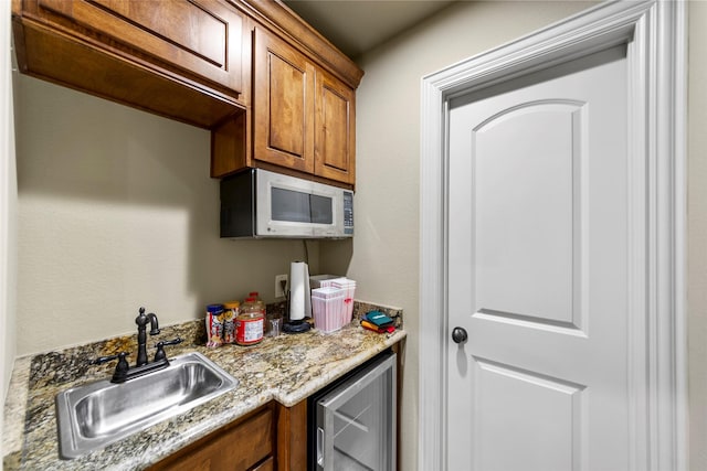 10528 Lago Vis, Quinlan, TX 75474 - kitchen featuring brown cabinets, light stone counters, a sink, and beverage cooler