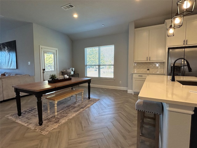 dining room featuring visible vents, baseboards, lofted ceiling, and recessed lighting