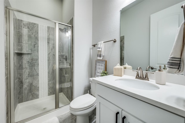 bathroom with vanity, toilet, and a stall shower