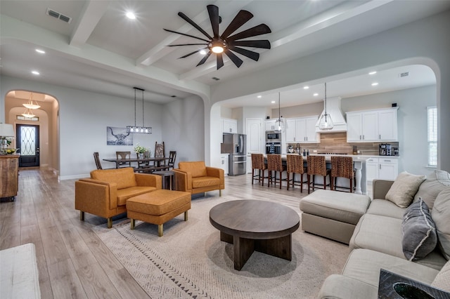 living room with arched walkways, recessed lighting, and ceiling fan