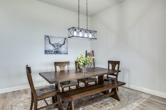 dining room featuring light wood finished floors and baseboards