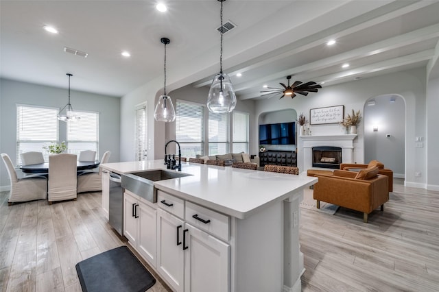 kitchen with visible vents, light wood-style flooring, ceiling fan with notable chandelier, and a sink