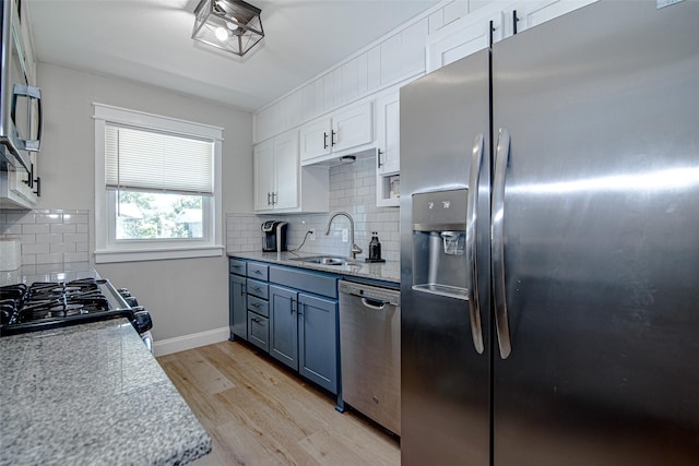 509 Oak St, Burleson, TX 76028 - kitchen with appliances with stainless steel finishes, light wood-style flooring, a sink, and backsplash
