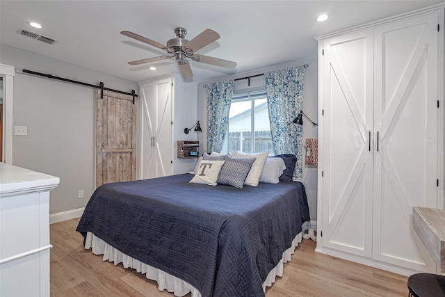 509 Oak St, Burleson, TX 76028 - bedroom with visible vents, a barn door, light wood-style flooring, and recessed lighting