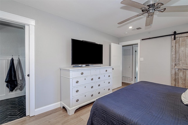 509 Oak St, Burleson, TX 76028 - bedroom featuring light wood-style flooring, a barn door, baseboards, a ceiling fan, and recessed lighting
