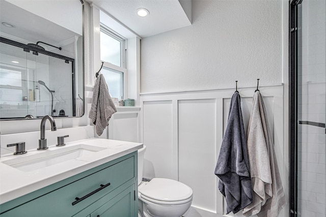 509 Oak St, Burleson, TX 76028 - bathroom with toilet, a stall shower, a wainscoted wall, a decorative wall, and vanity