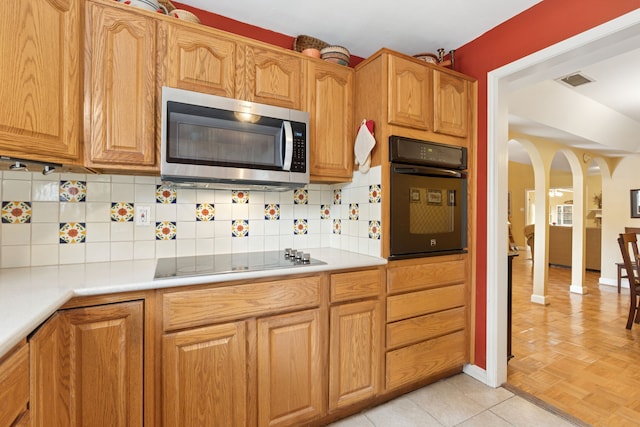 2177 Kessler Ct Unit 6, Dallas, TX 75208 - kitchen with light countertops, tasteful backsplash, arched walkways, and black appliances