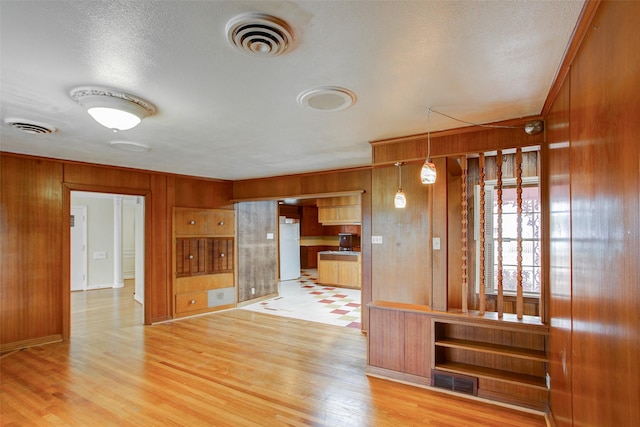2000 Standifer St, Fort Worth, TX 76164 - interior space featuring freestanding refrigerator, wood walls, light wood-type flooring, and visible vents