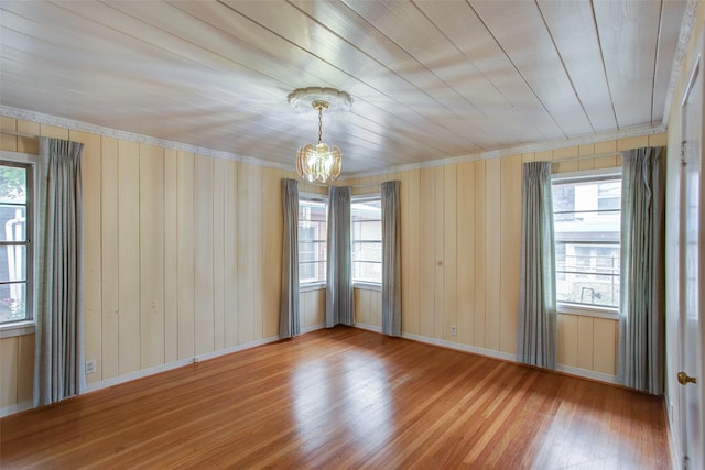 2000 Standifer St, Fort Worth, TX 76164 - spare room featuring wood finished floors, ornamental molding, baseboards, wooden walls, and a notable chandelier
