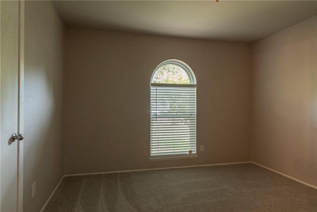 unfurnished room with carpet and baseboards