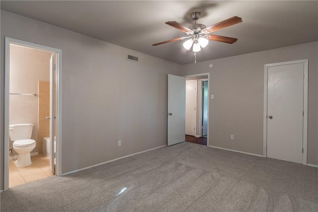 unfurnished bedroom with a ceiling fan, baseboards, ensuite bathroom, carpet flooring, and visible vents