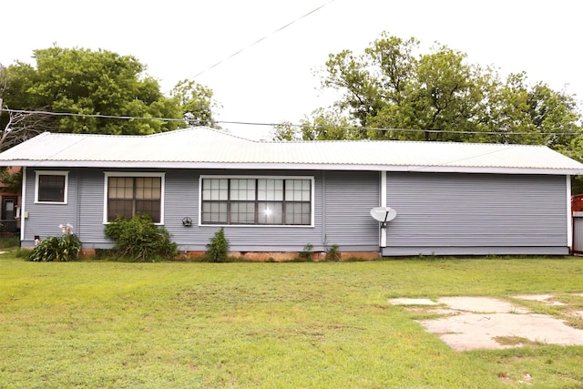 rear view of property with a yard, metal roof, and crawl space