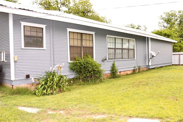 exterior space featuring a yard and metal roof