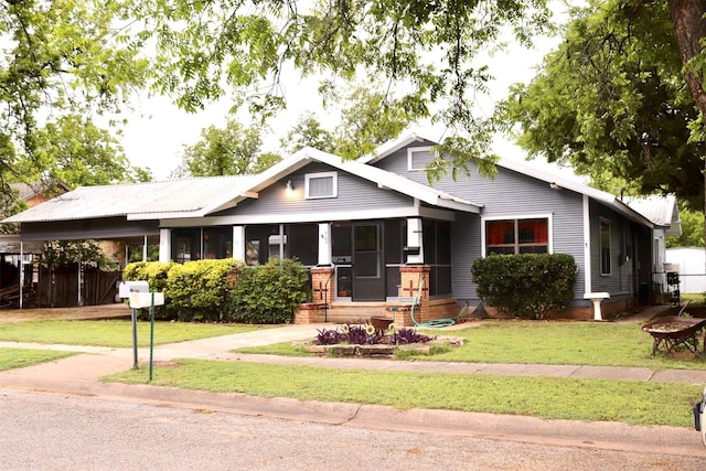 craftsman-style home featuring an attached carport, a front lawn, and fence