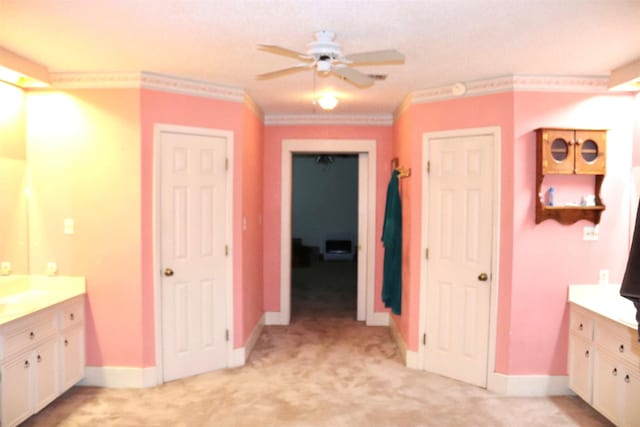 bathroom featuring ceiling fan, ornamental molding, baseboards, and vanity