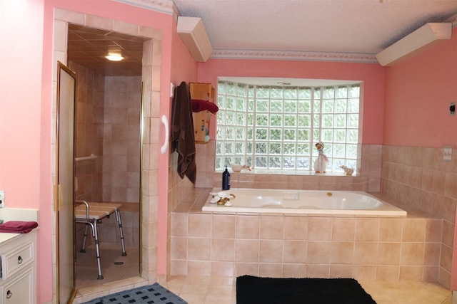 full bath featuring tile patterned floors, vanity, a garden tub, and a tile shower