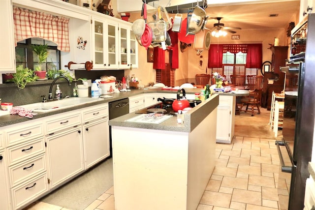 kitchen with a ceiling fan, a sink, a peninsula, a kitchen island, and stovetop