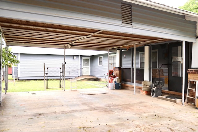 exterior space featuring brick siding, a gate, and a carport