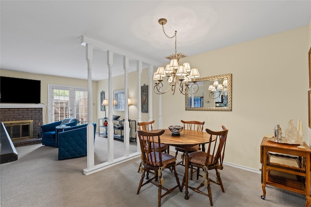 carpeted dining space featuring a fireplace and an inviting chandelier